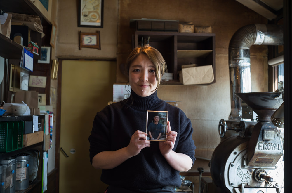 Mana Takahashi holding a photo of Masaaki Takahashi