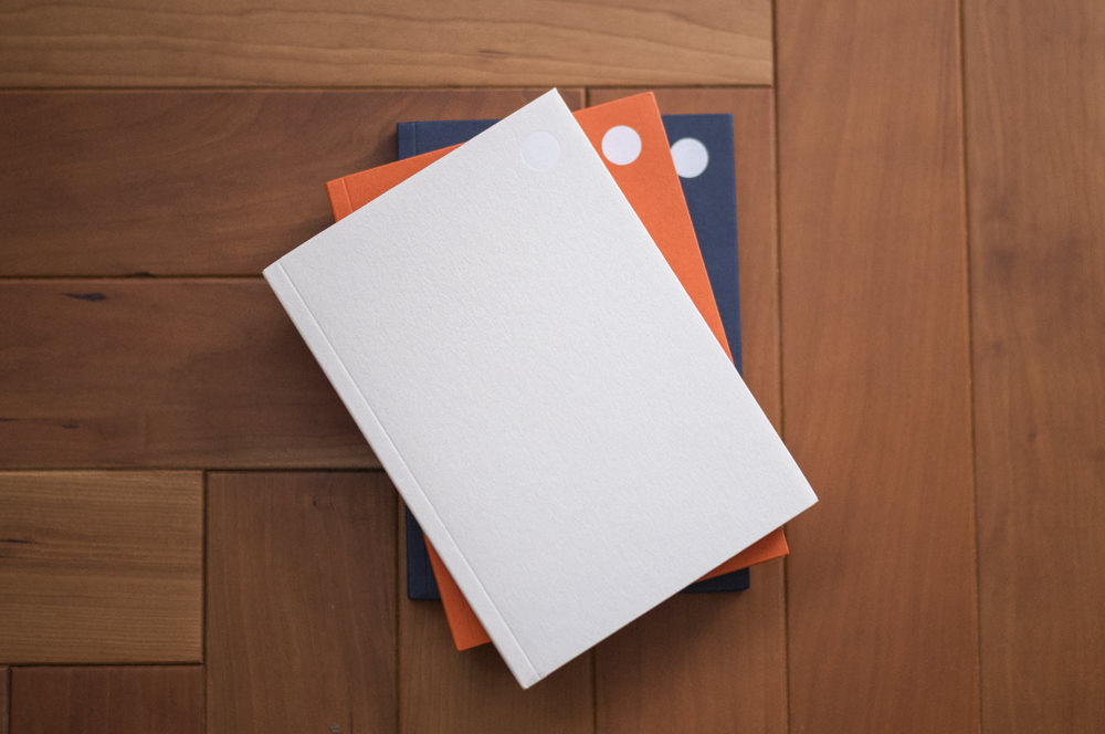 ⬤ notebooks in cream, orange, and navy